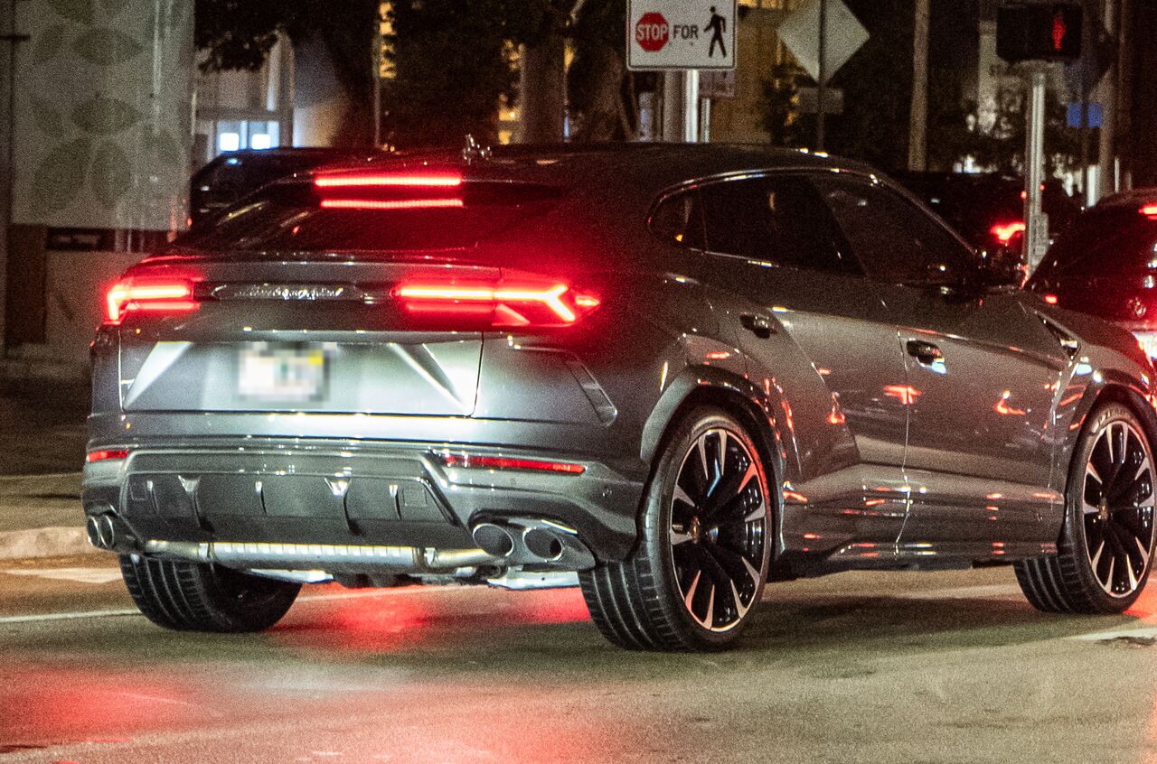 Traseira de um Lamborghini Urus cinza à noite, com a tampa do porta-malas fechada